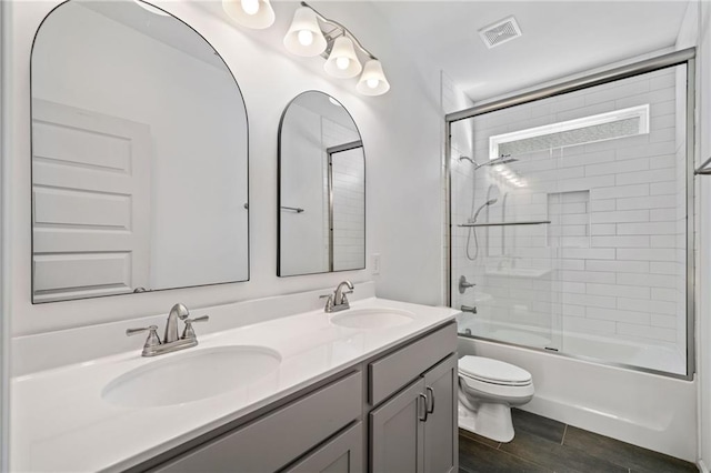 full bathroom with toilet, combined bath / shower with glass door, and vanity