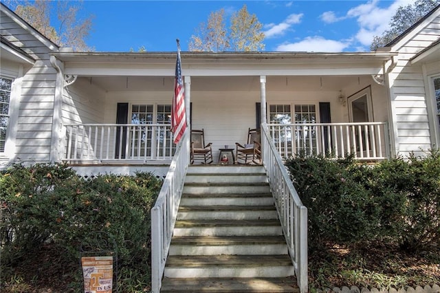 view of exterior entry featuring covered porch