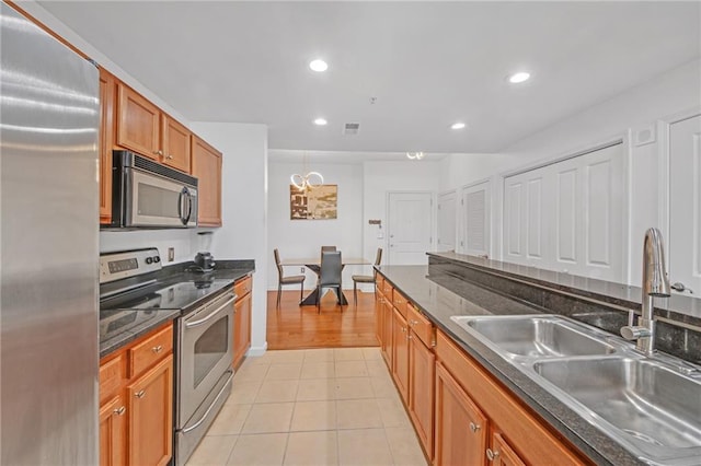 kitchen with stainless steel appliances, light tile patterned flooring, and sink