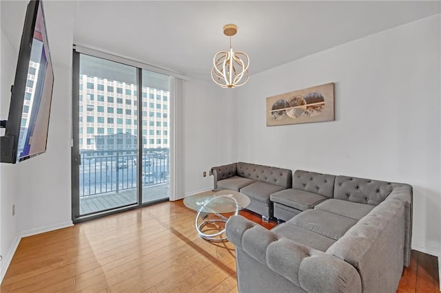 living room with expansive windows, hardwood / wood-style floors, and a chandelier