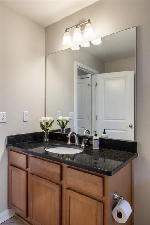 bathroom featuring tile patterned flooring, baseboards, and vanity