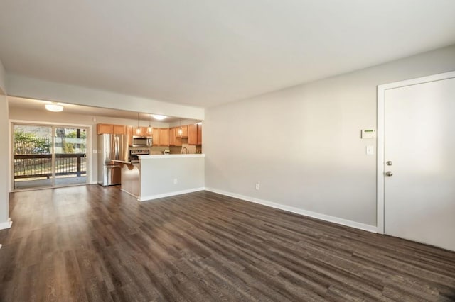 unfurnished living room featuring dark wood-style flooring and baseboards