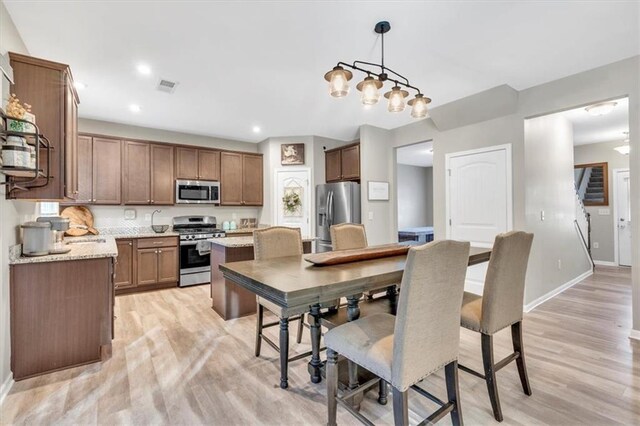 carpeted living room with ceiling fan with notable chandelier