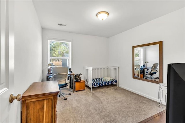 bedroom with a crib and light carpet