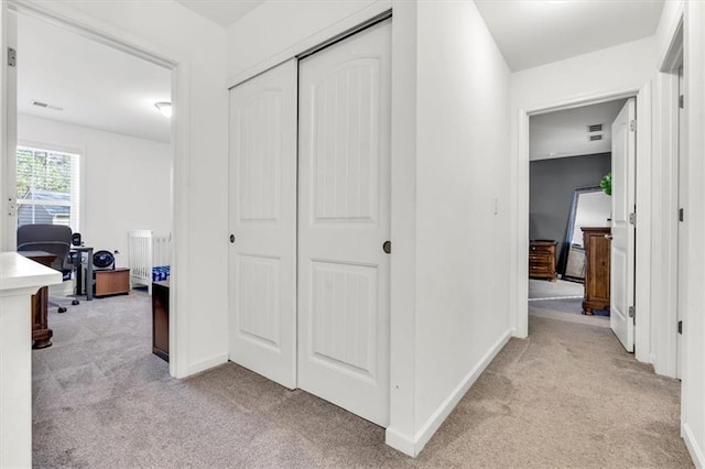 hall featuring light colored carpet