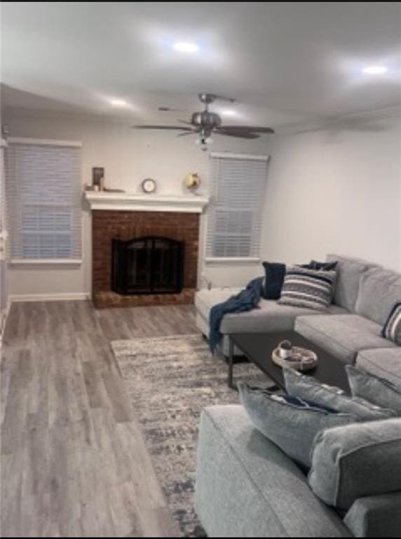 living room with a fireplace, hardwood / wood-style flooring, and ceiling fan