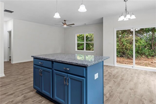 kitchen featuring a center island, blue cabinets, ceiling fan with notable chandelier, and light wood-type flooring