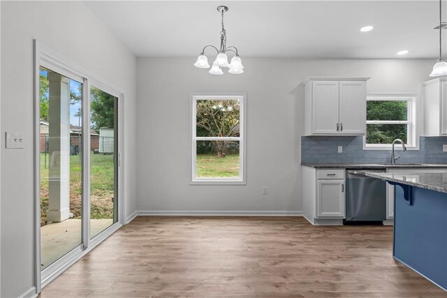 kitchen with stainless steel dishwasher, pendant lighting, and plenty of natural light