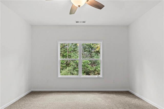 carpeted spare room featuring ceiling fan