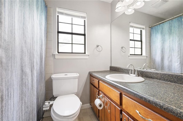 full bathroom featuring a shower with curtain, toilet, baseboards, visible vents, and vanity
