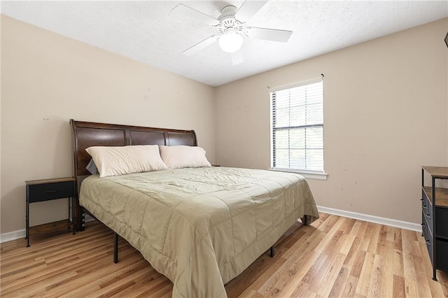 bedroom featuring baseboards, light wood-style flooring, and a ceiling fan