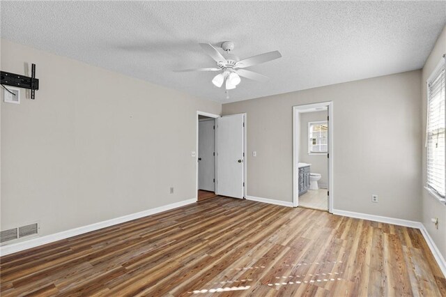 6165 Picketts Rdg NW, Acworth, GA 30101 - unfurnished bedroom featuring visible vents, connected bathroom, baseboards, and wood finished floors