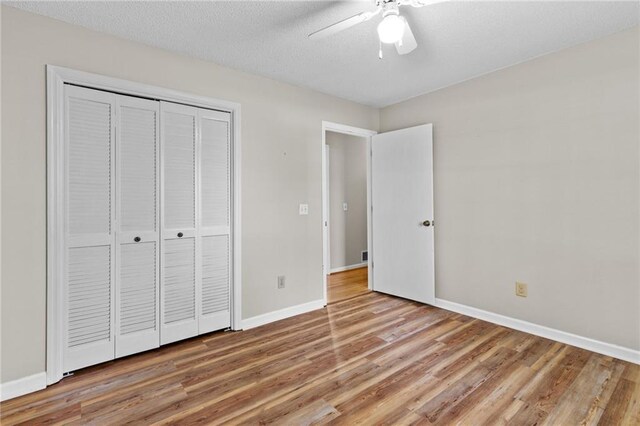 6165 Picketts Rdg NW, Acworth, GA 30101 - unfurnished bedroom featuring ceiling fan, baseboards, wood finished floors, a closet, and a textured ceiling