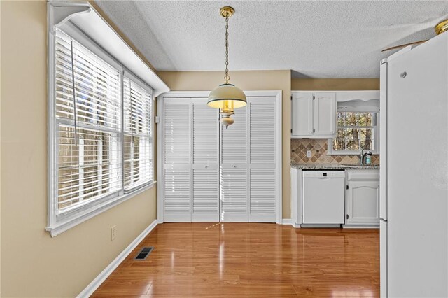 6165 Picketts Rdg NW, Acworth, GA 30101 - unfurnished dining area featuring visible vents, a sink, a textured ceiling, light wood-style floors, and baseboards