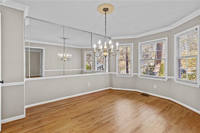 6165 Picketts Rdg NW, Acworth, GA 30101 - unfurnished dining area featuring wood finished floors, plenty of natural light, a chandelier, and crown molding