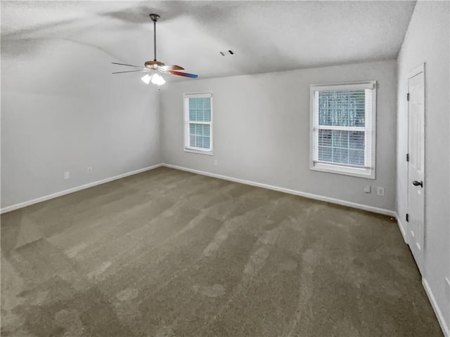 carpeted spare room featuring vaulted ceiling and ceiling fan