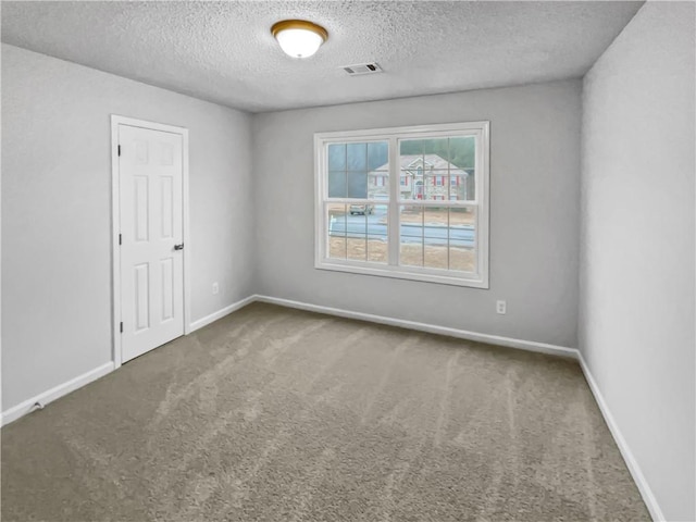 empty room featuring a textured ceiling and carpet