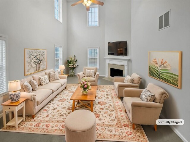 living room featuring ceiling fan and a high ceiling