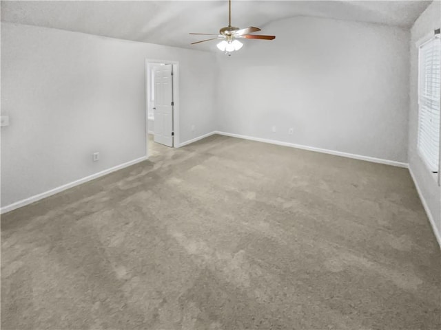 empty room with ceiling fan, carpet flooring, and vaulted ceiling