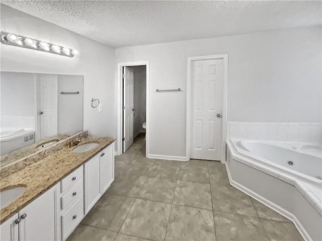 bathroom featuring tile patterned flooring, vanity, a textured ceiling, a tub to relax in, and toilet