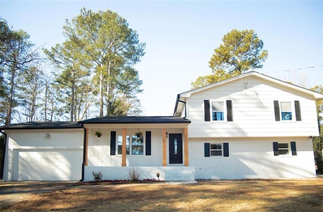 split level home featuring covered porch and a garage