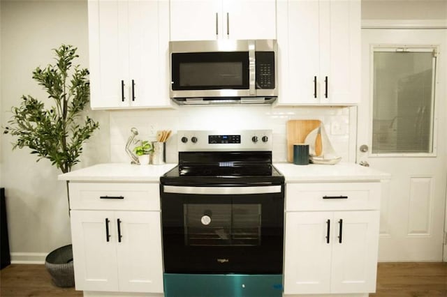 kitchen featuring decorative backsplash, white cabinetry, and stainless steel appliances