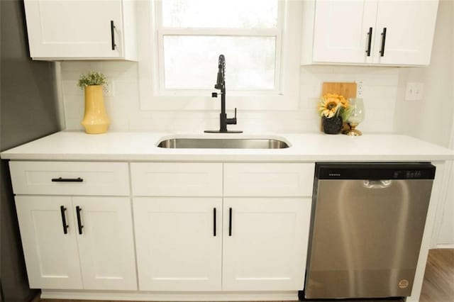 kitchen featuring decorative backsplash, sink, white cabinetry, and dishwasher