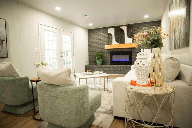 living room with french doors, a fireplace, and wood-type flooring