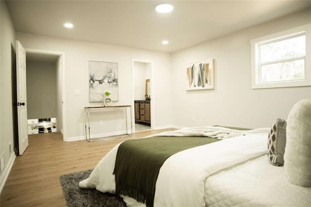 bedroom with wood-type flooring and ensuite bath