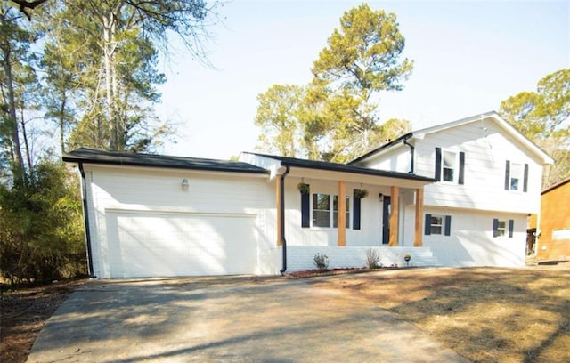 split level home featuring covered porch and a garage