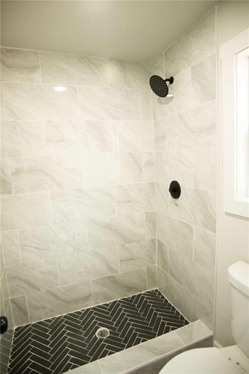 bathroom featuring toilet and tiled shower