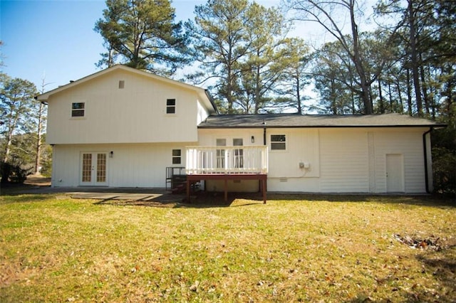 back of property with a lawn, french doors, and a wooden deck