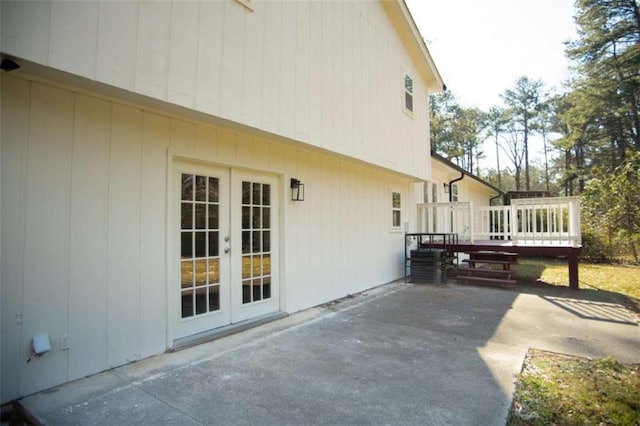 view of side of home featuring french doors, a deck, and a patio