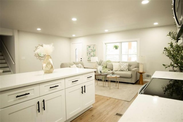 kitchen with light wood-type flooring and white cabinetry