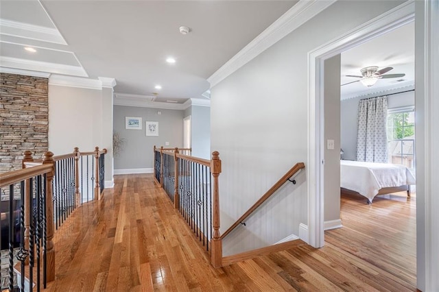 hall featuring an upstairs landing, crown molding, baseboards, light wood finished floors, and recessed lighting