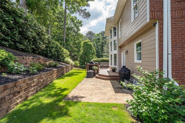 view of yard with a deck and a patio