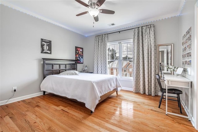 bedroom featuring ornamental molding, baseboards, light wood-style floors, an office area, and a ceiling fan