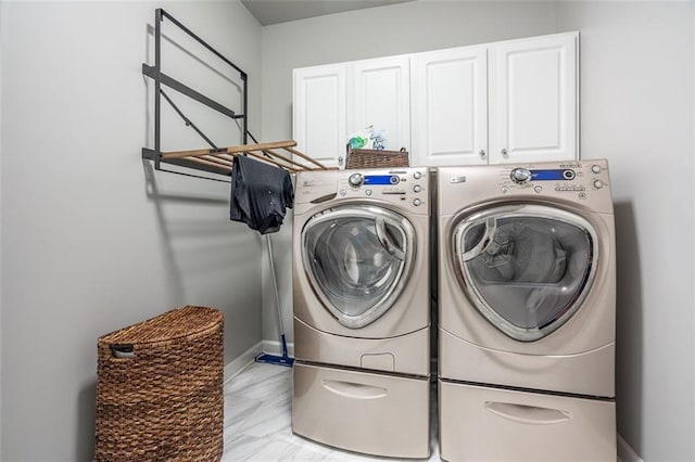 laundry room with cabinet space, independent washer and dryer, and baseboards