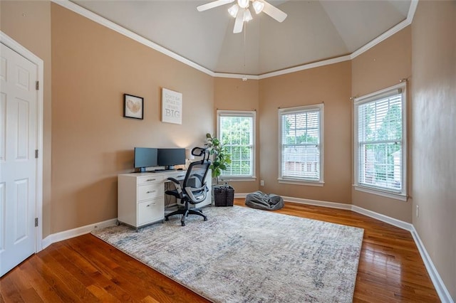 office space with wood finished floors, baseboards, a ceiling fan, vaulted ceiling, and crown molding