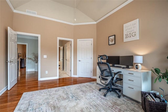 office area featuring wood finished floors, baseboards, crown molding, and high vaulted ceiling