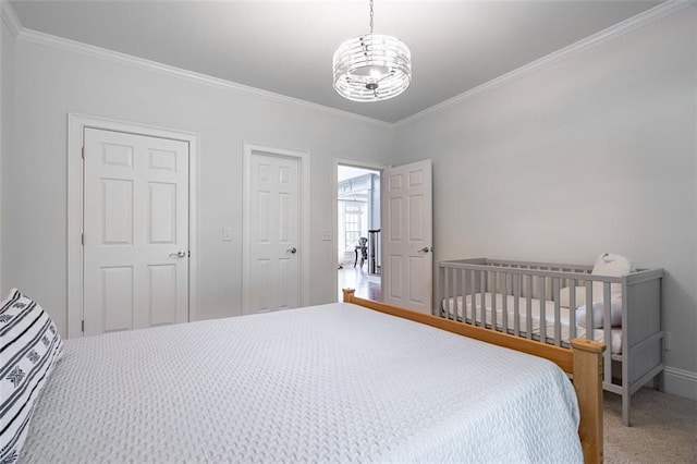 bedroom with ornamental molding, carpet floors, a chandelier, and baseboards