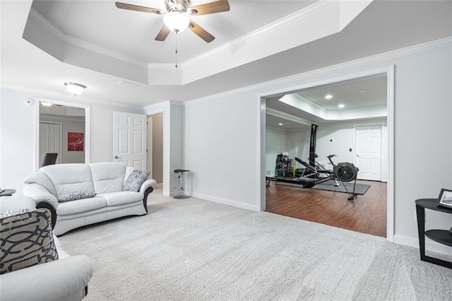 carpeted living room with a tray ceiling, crown molding, a ceiling fan, baseboards, and recessed lighting