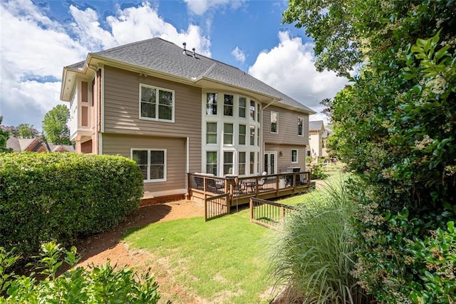 back of house with a lawn and a deck