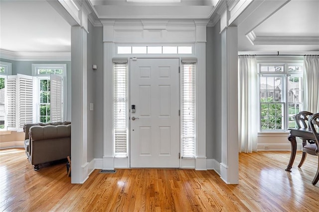 foyer featuring ornamental molding, baseboards, and light wood-type flooring