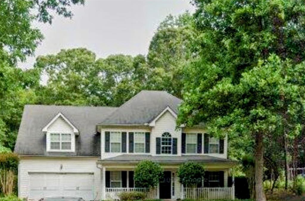 colonial home featuring a garage and covered porch