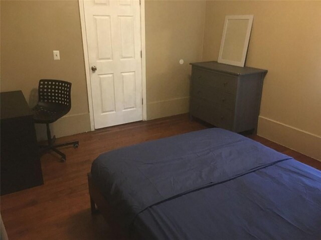 bedroom with baseboards and wood finished floors