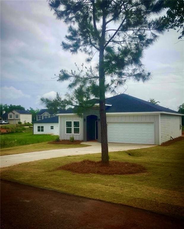 view of front of property featuring a garage, a front lawn, and driveway