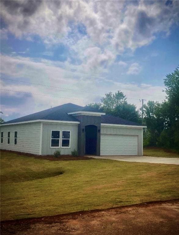 single story home featuring driveway, a front yard, and a garage