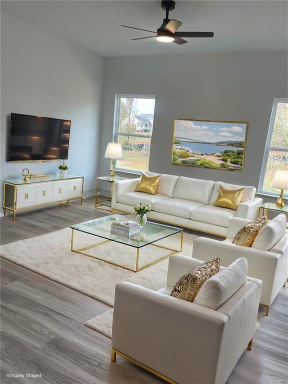 living area with baseboards, a ceiling fan, and wood finished floors