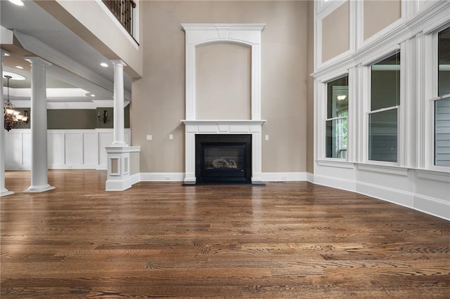 771 Tate Overlook, Marietta, GA 30064 - unfurnished living room with dark wood finished floors, ornate columns, a high ceiling, a fireplace with flush hearth, and baseboards